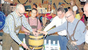 Bürgermeister Michael Franz unterstützt von Tobias Eckert, Christoph Heep und Kai Müller (Musikverein) (v. li.) beim Fassbieranstich.